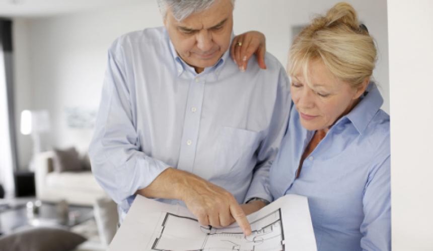 Older couple looking at plans to renovate their home. 