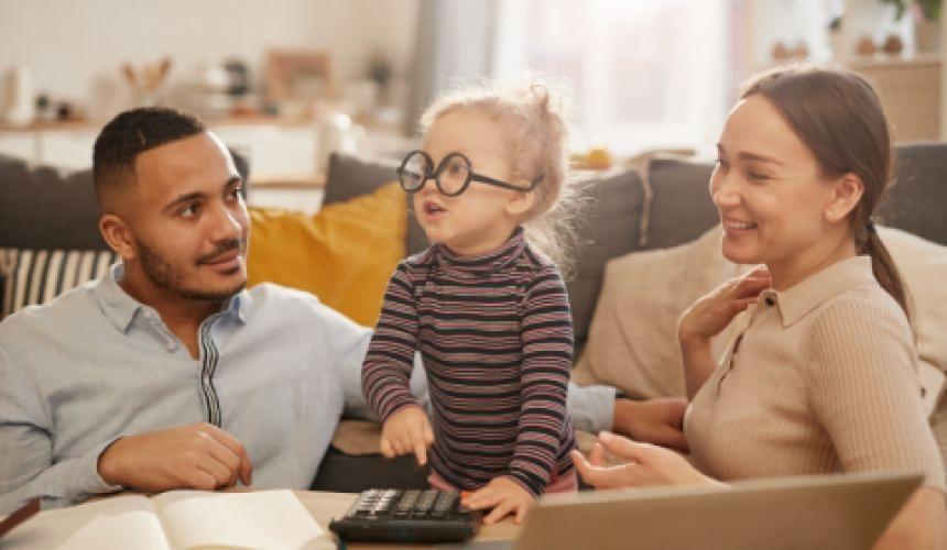 Husband and wife interrupted by cute baby while working on finances